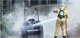  ?? PHOTO: PETER MCINTOSH ?? On the scene . . . Firefighte­rs extinguish yesterday’s tractor blaze.