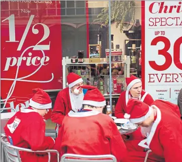  ??  ?? Some charity run Santas take a break in front of Christmas sales but are stores struggling?
