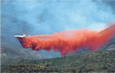  ?? PHOTOS BY DAVID WALLACE/THE REPUBLIC ?? A DC-10, photograph­ed from Peeples Valley, drops fire retardant on the Tenderfoot Fire on Friday. The fire has burned about 3,300 acres.