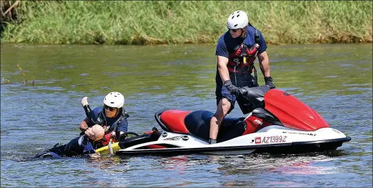  ?? Buy these photos at YumaSun.com PHOTOS BY RANDY HOEFT/YUMA SUN ?? YUMA FIRE DEPARTMENT FIREFIGHTE­R FERNANDO QUINTERO (LEFT) pulls “Rescue Randy” from the Colorado River and onto a rescue sled as Francisco Leon pilots the watercraft during a watercraft training session Monday morning at Centennial Beach inside West Wetlands Park.