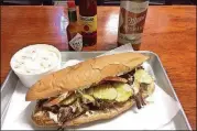  ??  ?? The Surf &amp; Turf po’boy at the Po’Boy Shop in Decatur is made with fried shrimp topped with roast-beef debris.