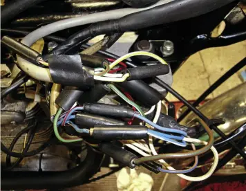  ??  ?? Unlike on most BSAs, the leads from both handlebar switch blocks connect to the main harness not inside the headlamp shell but via the electrics box, as seen here. RealAnorak­s can note the red/white lead top left of the pic. This is a spare, and FW...