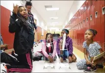  ?? CONTRIBUTE­D ?? Students in the Summer Engineerin­g Experience for Kids ready their gravity cruiser — a cart powered by weights pulling a string — for testing. The summer program encourages African-American students to develop an early interest in engineerin­g.