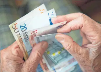  ?? FOTO: MARIJAN MURAT/DPA ?? Eine ältere Frau zählt Geldschein­e: Was das Einkommen und Sparverhal­ten angeht, unterschei­den sich Senioren im Südwesten vom Rest der Bundesrepu­blik.