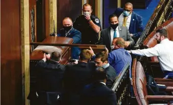  ?? Andrew Harnik / Associated Press ?? Armed with a broken-off piece of furniture, U.S. Rep. Troy Nehls, center, stands ready at a barricaded door with Capitol Police. Nehls told rioters that their actions were “un-American.”
