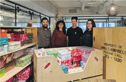  ??  ?? Christmas boxes full of such items as mitts, scarves, hats, soap and tooth brushes will be delivered shortly. From left are Michael Tandara and Shavonne Doell of Dream Unlimited and Ben Campbell and Krista O’Neill of AMJ Campbell which donated time and...