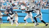  ?? Grant Halverson / Getty Images ?? Dallas QB Dak Prescott runs from Carolina defenders Shaq Green-Thompson, center, and Bryan Cox during the Panthers’ 16-8 opening day win Sunday. Carolina’s defense had Prescott on the run all day collecting six sacks and clinching the win by forcing a fumble on the Cowboys’ last possession.