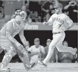  ?? Harry How Getty Images ?? THE ANGELS’ Cliff Pennington scores easily on a Mike Trout single during a four-run seventh inning Friday night. The late rally was enough to secure a win.