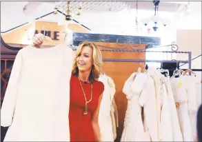  ?? Hearst Connecticu­t Media file photo ?? Greenwich resident and TV co-host Lara Spencer looks at wedding gowns at the Greenwich Hospital Auxiliary Thrift Shop in 2012 for a segment on thrift stores on “Good Morning America.”