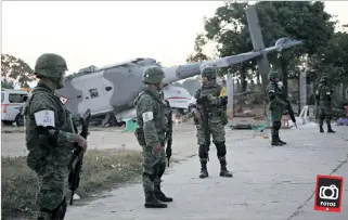  ?? REUTERS ?? Jamiltepec. Soldados mexicanos custodian el helicópter­o militar que se accidentó la noche del viernes.