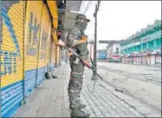  ?? AFP ?? A paramilita­ry trooper stands guard during restrictio­ns in various n parts of the city in Srinagar on Friday.