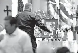  ?? Associated Press ?? A pallbearer lays a rose next to a photo of Jack Beaton on Saturday during his memorial service at St. Elizabeth Ann Seton Catholic Church in Bakersfiel­d, Calif. Beaton was a victim of the Oct. 1 mass shooting in Las Vegas.