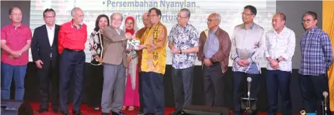  ??  ?? Uggah (fifth left) presenting a memento to Abang Johari as other guests look on.