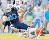  ?? GRANT HALVERSON/GETTY IMAGES ?? Jake Bargas of North Carolina is tackled by Miami’s Jaquan Johnson during Saturday’s game in Chapel Hill.