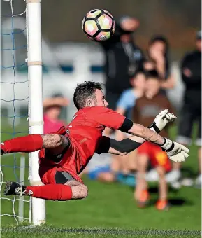  ?? CHRIS SYMES/PHOTOSPORT ?? Nelson Suburbs goalkeeper Corey Wilson dives in vain as Birkenhead United’s Christian Gray scores from the penalty spot in the Auckland team’s 2-0 win in their Chatham Cup semifinal.