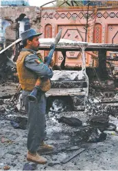  ?? PHOTO AFP ?? Un membre des forces de sécurité afghanes inspecte le site de l’attaque à la voiture piégée, hier, à Jalalabad.