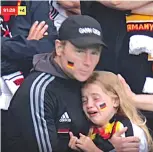  ??  ?? DEFLATED. . . A German kid slumps into the arms of her father as she mourns her team’s defeat on Tuesday