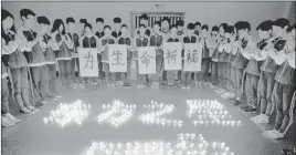  ?? ReuteRs ?? Students pray for passengers on a sunken cruise ship Wednesday at a school in Zhuji, China. More than 400 people remain missing after the vessel capsized in a tornado.