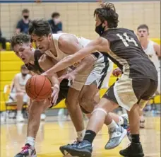  ?? Emily Matthews/Post-Gazette ?? Defense has been a key for Highlands' early success as Jimmy Kunst, left, and Carter Leri, right, stop Mars' Mihali Sfanos from driving Jan. 15 at Mars.