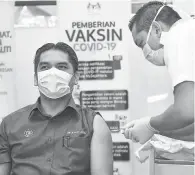  ?? — Gambar Bernama ?? VAKSIN: Dr Radzi menerima suntikan vaksin COVID-19 jenis Pfizer BioNTech oleh vaksinator Muhammad Bakhrul Ulum Mohd Rashid di Pejabat Kesihatan Putrajaya, Presint 11 semalam.