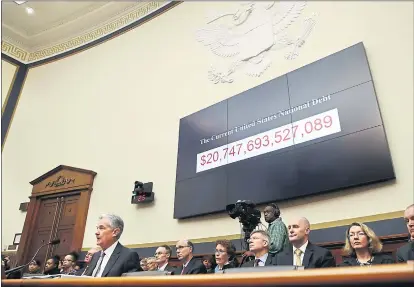  ?? PHOTOS: JACQUELYN MARTIN — THE ASSOCIATED PRESS ?? The National debt looms behind Federal Reserve Chairman Jerome Powell during his report to the House Financial Services Committee.