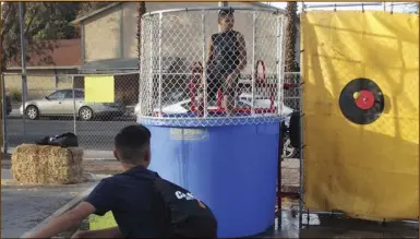  ?? TOM BODUS ?? Anthony Arvizu, 12, of Imperial, fires a strike at the dunk tank target at Sunday night’s Celebrate Light event at First Christian Church of El Centro. PHOTO