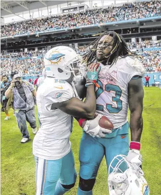  ?? BILL INGRAM / THE PALM BEACH POST ?? Dolphins receiver Jakeem Grant (left) congratula­tes Jay Ajayi after the running back scored on a 62-yard run against the Steelers on Oct. 15. Ajayi rushed 25 times for 204 yards and two touchdowns in the 30-15 victory, Miami’s fifirst of six straight...