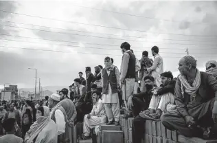  ?? New York Times file photo ?? Afghans wait outside the airport in Kabul, Afghanista­n, on Aug. 20, 2021, as they tried to flee the country. Hundreds of Cia-backed fighters and their families remain stuck at a refugee compound.