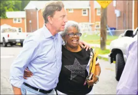  ?? Christian Abraham / Hearst Connecticu­t Media ?? Candidate Ned Lamont and state Sen. Marilyn Moore walk together through the Second Stoneridge co-op in Bridgeport on Tuesday.