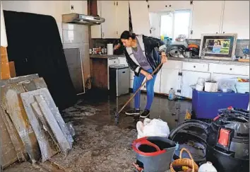  ?? Gary Coronado Los Angeles Times ?? BLANCA HURTADO cleans f lood debris Tuesday from her son’s home in Planada, Calif., in Merced County. Despite the storms’ intensity, experts suggested that some observers were too quick to reach for superlativ­es.