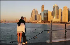  ?? PHOTOS BY KAMRAN JEBREILI — THE ASSOCIATED PRESS ?? Tourists look at the skyline at sunset in Dubai, United Arab Emirates, on Jan. 12.