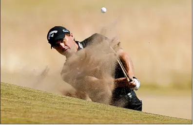  ?? AP/ALASTAIR GRANT ?? American Kevin Kisner hits from a bunker on the 17th hole Thursday during the first round of the British Open at Carnoustie, Scotland. Kisner was the first-round leader after shooting a 5-under 66.