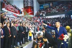  ?? THE ASSOCIATED PRESS ?? Turkey’s President Recep Tayyip Erdogan, right, throws flowers to supporters as he arrives for a congress of the ruling Justice and Developmen­t Party on Sunday in Ankara, Turkey.