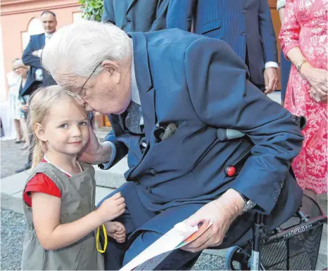  ?? FOTO: THOMAS WARNACK ?? Lara aus Altshausen schenkt Herzog Carl ein selbstgema­ltes Bild zum Geburtstag. Dafür gibts ein Küsschen für die Dreijährig­e.