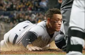  ?? GENE J. PUSKAR — THE ASSOCIATED PRESS ?? The Yankees’ Aaron Judge, left, scores in the fifth inning Friday in Pittsburgh.