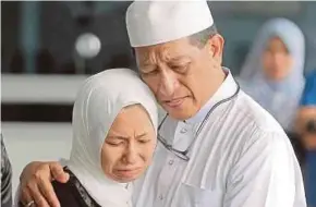  ??  ?? Qistina memeluk bapanya, Rozhan ketika menunggu keputusan bedah siasat di Hospital Serdang.