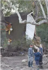  ?? Right: ?? Members of a Cal Fire inmate crew search for people still missing in the aftermath of a massive mudslide in Montecito, California. (in cowboy hat) and neighbours look over the mud, debris and destructio­n. Local resident Greg Duimovich