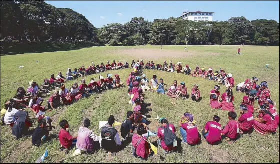  ?? MICHAEL VARCAS ?? Lumad children form a peace sign at the University of the Philippine­s’ Sunken Garden in Diliman, Quezon City during a cultural festival yesterday.