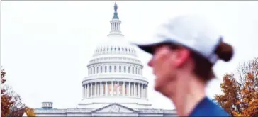  ?? MANDEL NGAN/AFP ?? A woman passes in front of the US Capitol in Washington, District of Columbia, on November 6 as Americans started voting in mid-term elections.