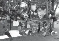  ?? Associated Press ?? ■ Items left by fans at a memorial for Prince hang from a fence outside the musician's Paisley Park estate in Chanhassen, Minn. Work to settle the estate of the late rock superstar is moving forward, though a closed hearing is expected this week to...