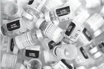  ?? JOHN LOCHER/AP ?? Empty vials of the Pfizer vaccine pile up Jan. 22 at a vaccinatio­n center in Las Vegas. Makers of COVID-19 vaccines need everything to go right as they scale up from early-stage production to hundreds of millions of doses.