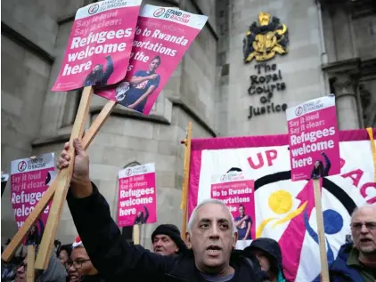  ?? ?? Stand Up To Racism campaigner­s hold banners outside the High Court in London, Monday, Dec. 19, 2022. Photo: AP/Kirsty Wiggleswor­th, File.