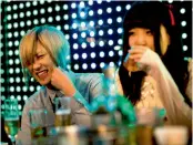  ?? — AFP ?? A file picture shows a male host sharing a light moment with a female customer at a host club in the Kabukicho red-light district in Tokyo.