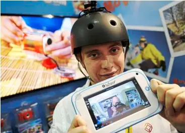  ??  ?? In praise of technology: alexandra delage from Lexibook holds a tablet, connected wirelessly to a mini camera attached to a helmet, during the Toy Fair at Olympia exhibition centre in London. — aFP