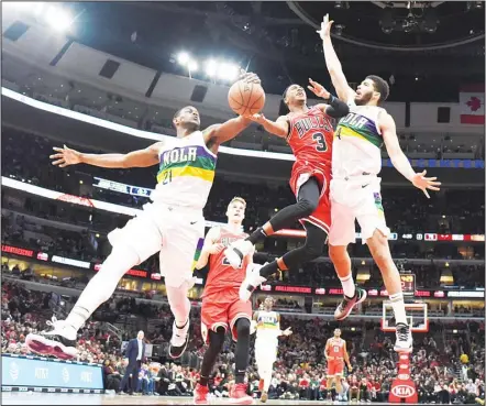  ??  ?? Chicago Bulls guard Shaquille Harrison (3) is defended by New Orleans Pelicans forward Darius Miller (21) and guard Kenrich Williams, (right), duringthe second half of an NBA basketball game Feb 6 in Chicago. The Pelicans won 125-120. (AP)