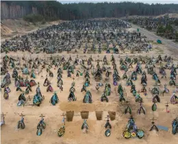  ?? DAVID GUTTENFELD­ER/THE NEW YORK TIMES ?? Four more freshly dug graves await Saturday among the rows of those added to a cemetery in Irpin, Ukraine, since the Russian invasion began.