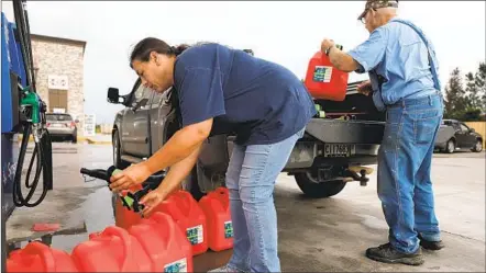  ?? MARIO TAMA GETTY IMAGES ?? Local residents place unfilled gas cans back in their truck after discoverin­g there was no regular gasoline left at the station as they prepare for Hurricane Delta on Thursday in Lacassine, La. Delta strengthen­ed Thursday to a Category 3 storm.