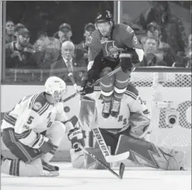  ?? JANA CHYTILOVA/FREESTYLE PHOTO, GETTY IMAGES ?? Bobby Ryan of the Senators jumps as the puck is shot and Henrik Lundqvist of the Rangers makes a save. Rangers’ Dan Girardi looks on at the action in Game 1 Thursday.