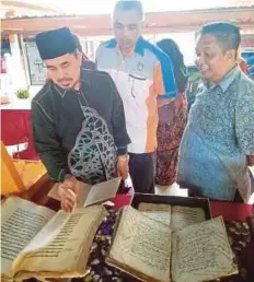  ??  ?? DR Abdul Jalil (kiri) melihat manuskrip lama sambil disaksikan Wan Ahmad (kanan).