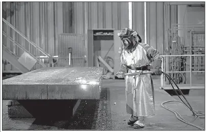  ?? Bloomberg/COLE BURSTON ?? An employee performs a quality check on a steel slab at the Stelco Holdings Inc. plant in Nanticoke, Ontario, last month.